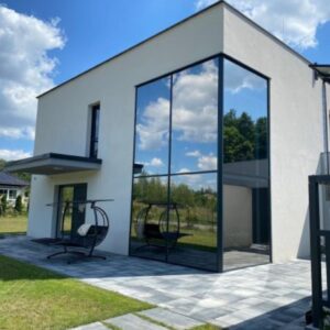 Folia przeciwsłoneczna na dużych oknach domu jednorodzinnego ograniczająca nagrzewanie wnętrz